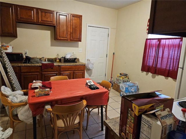 kitchen featuring dark stone countertops and light tile floors