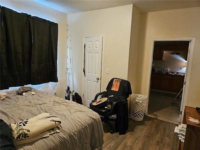 bedroom featuring connected bathroom and dark wood-type flooring