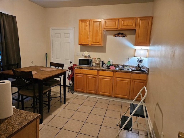 kitchen featuring light tile floors and dark stone countertops