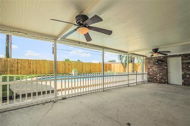 unfurnished sunroom with ceiling fan