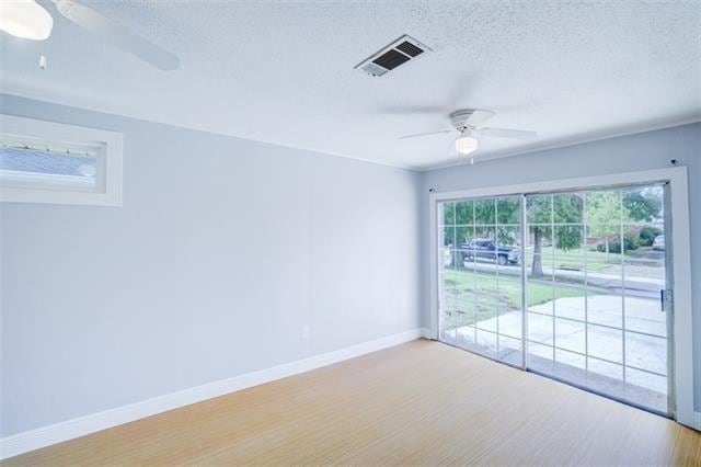 spare room featuring ceiling fan, a textured ceiling, and light wood-type flooring