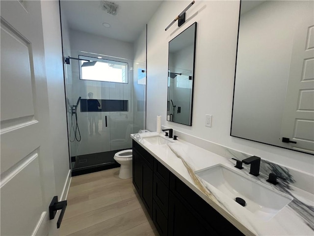 bathroom with wood-type flooring, vanity, toilet, and walk in shower