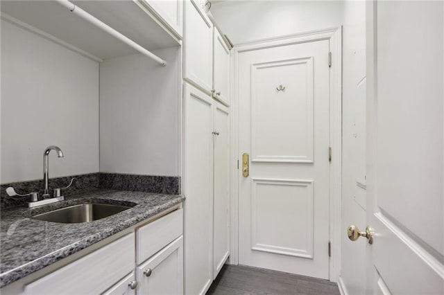 laundry area featuring dark wood-type flooring and sink