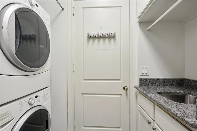 laundry room with cabinets and stacked washer / dryer