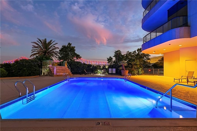 pool at dusk with a patio