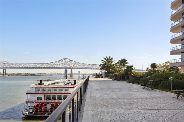 view of patio featuring a water view and a balcony