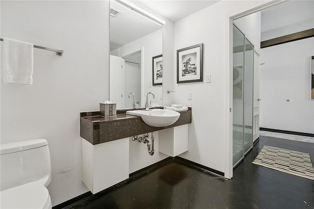 bathroom featuring concrete flooring, sink, and toilet