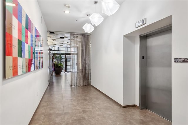 hall featuring elevator and light tile floors