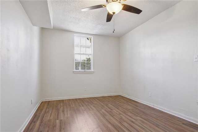 empty room featuring ceiling fan, a textured ceiling, and dark hardwood / wood-style floors