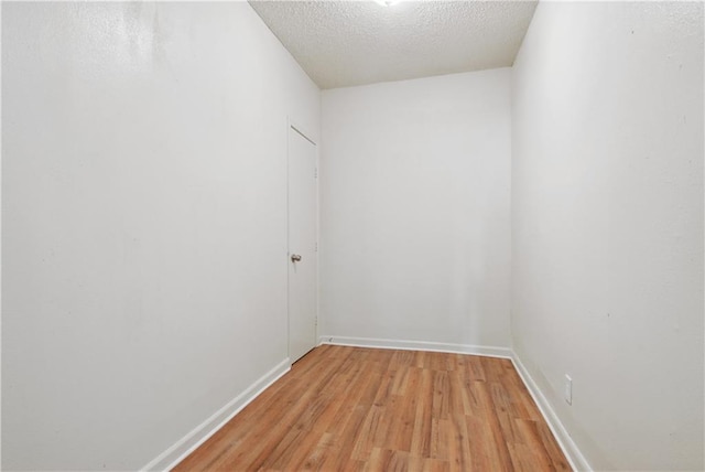 spare room featuring a textured ceiling and light wood-type flooring