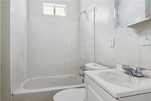 full bathroom featuring toilet, vanity, and tiled shower / bath