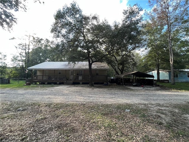 view of yard with covered porch and a carport