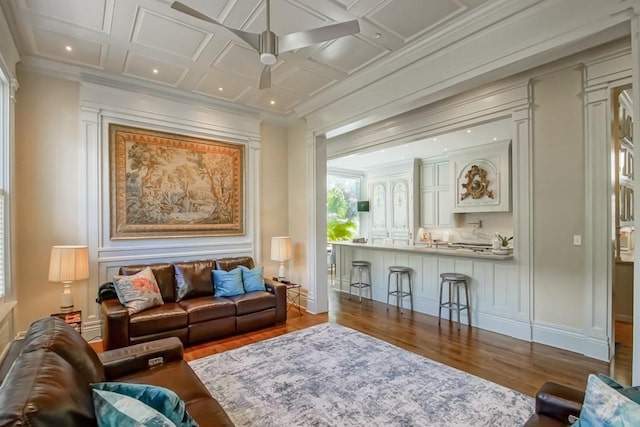 living room featuring coffered ceiling, crown molding, beam ceiling, ceiling fan, and hardwood / wood-style floors