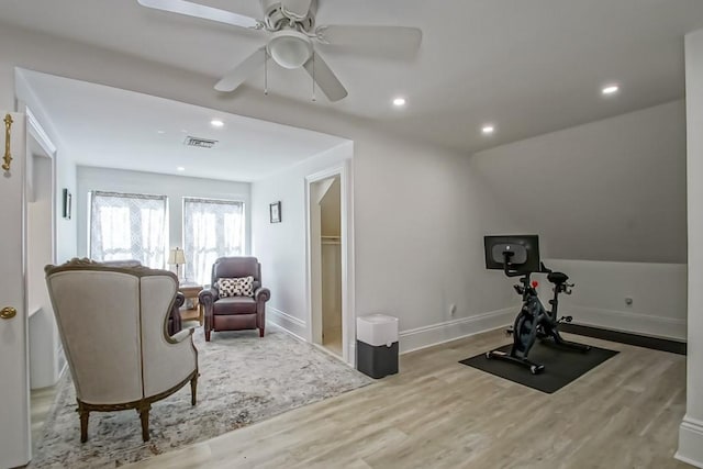 workout room with ceiling fan, lofted ceiling, and hardwood / wood-style floors