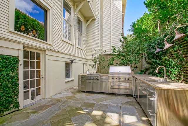 view of patio featuring area for grilling, sink, and a grill