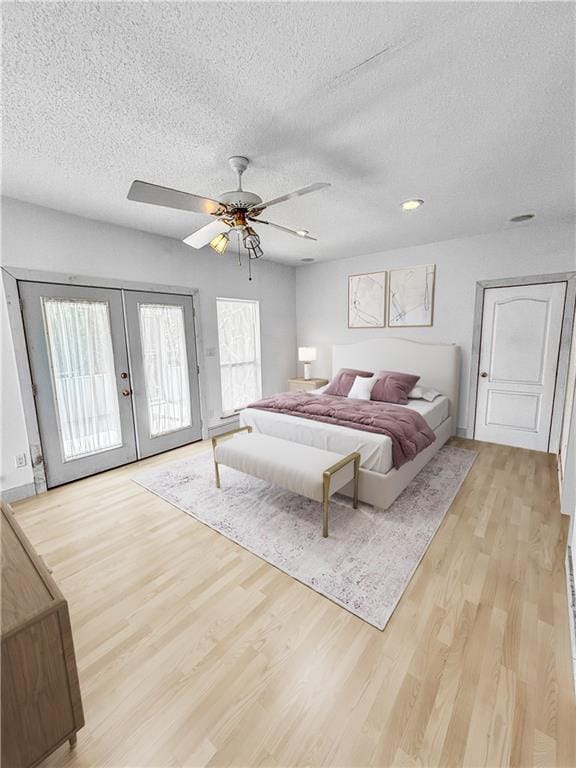 bedroom with access to exterior, ceiling fan, french doors, and light wood-type flooring