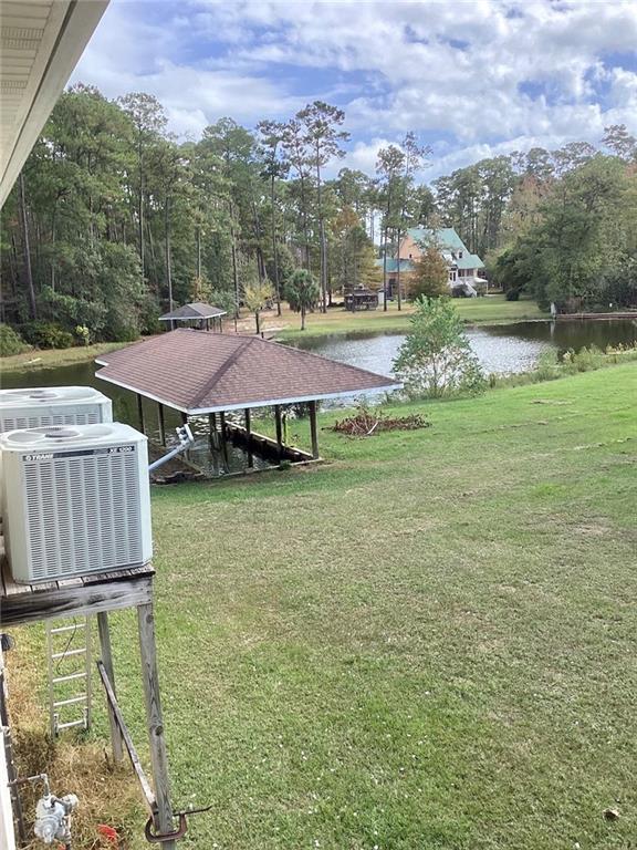 view of yard with central AC and a water view