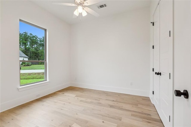 spare room featuring ceiling fan, a wealth of natural light, and light hardwood / wood-style flooring