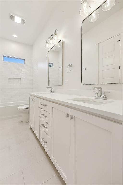 full bathroom featuring tile patterned floors, toilet, vanity, and tiled shower / bath