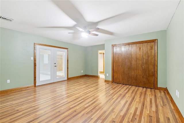 unfurnished bedroom featuring ceiling fan, light wood-type flooring, and french doors