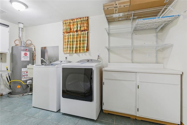 laundry room with gas water heater, cabinets, light tile floors, and washer and clothes dryer