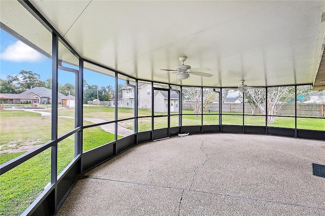 unfurnished sunroom featuring ceiling fan