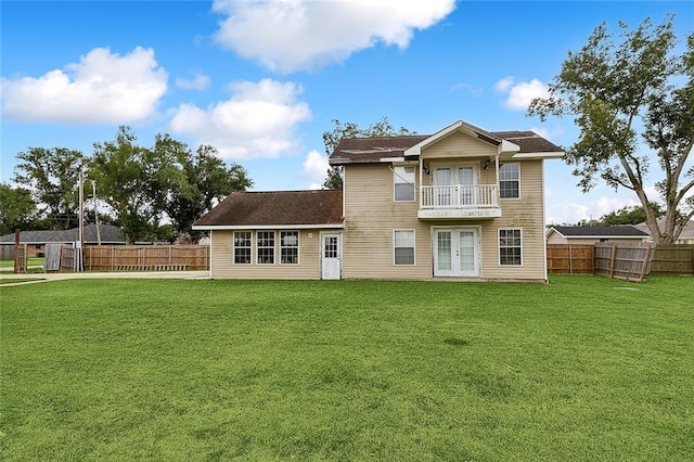 back of property featuring a balcony and a lawn