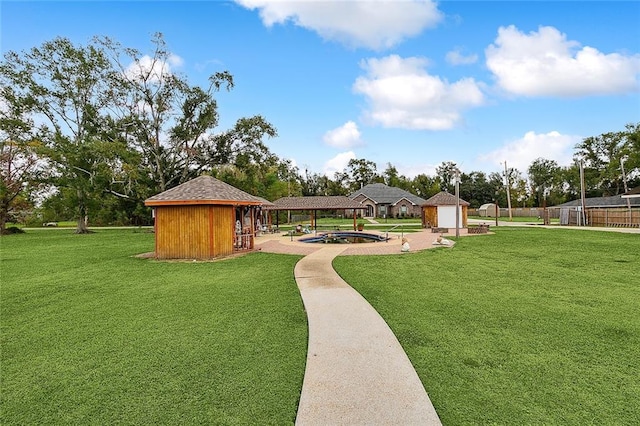 view of property's community with a lawn and a storage unit