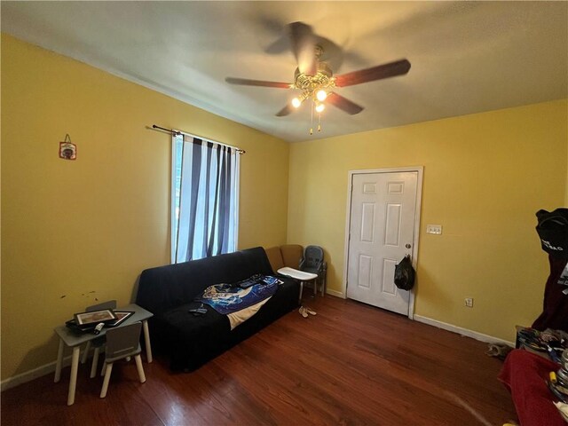 living room with ceiling fan and dark hardwood / wood-style flooring