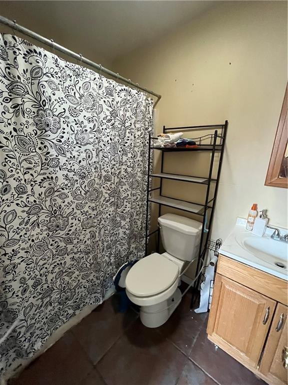 bathroom with toilet, tile flooring, and vanity