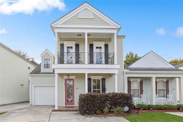 greek revival inspired property featuring a balcony, a porch, and a garage