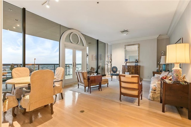 interior space with french doors, ornamental molding, and light hardwood / wood-style flooring