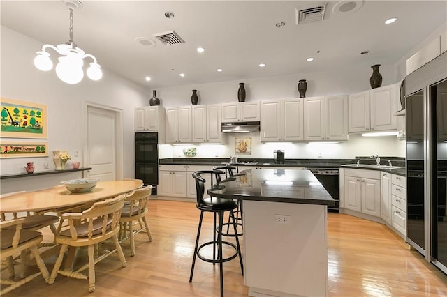 kitchen featuring white cabinets, black appliances, and a kitchen island