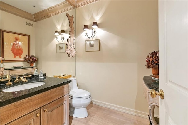 bathroom featuring ornamental molding, vanity, hardwood / wood-style floors, and toilet