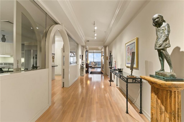 hall with crown molding and light hardwood / wood-style flooring