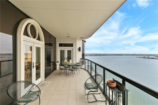 balcony with french doors and a water view