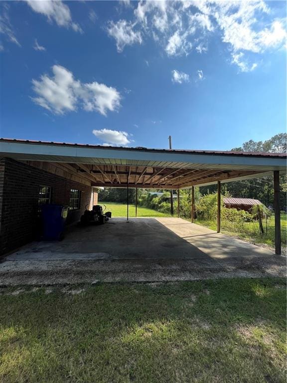 view of vehicle parking with a carport and a lawn