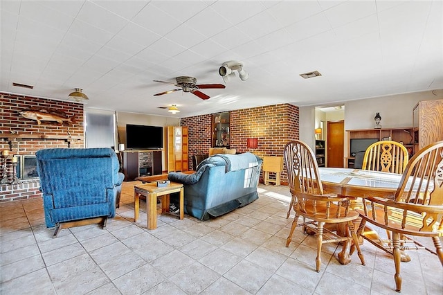 tiled dining space with brick wall, a fireplace, and ceiling fan