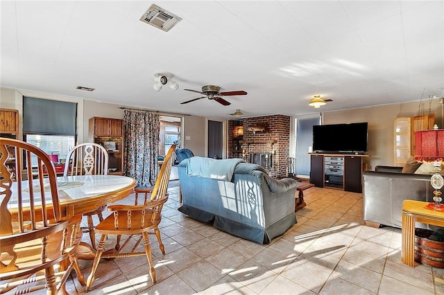 tiled living room with brick wall, ceiling fan, and a fireplace