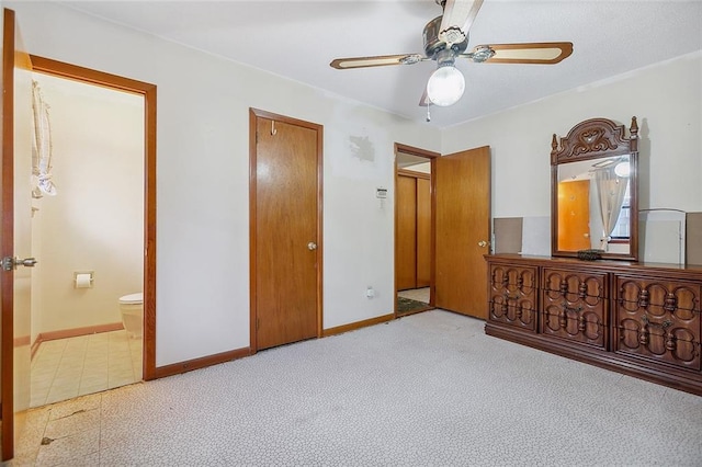 carpeted bedroom featuring ensuite bath and ceiling fan