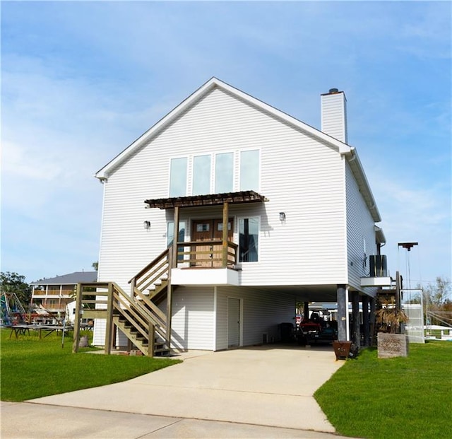 rear view of house featuring a lawn and a carport