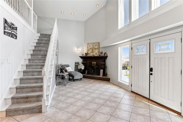 entryway with light tile patterned floors and a high ceiling