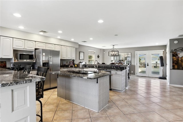 kitchen with pendant lighting, appliances with stainless steel finishes, kitchen peninsula, and a wealth of natural light