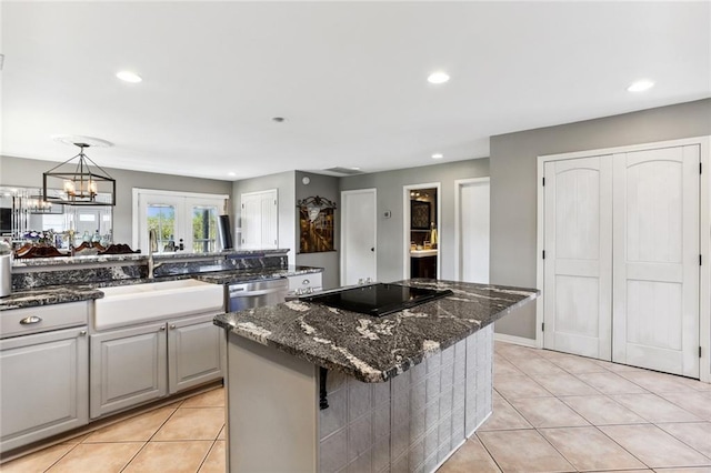 kitchen featuring a kitchen bar, dark stone countertops, a center island, and light tile patterned floors