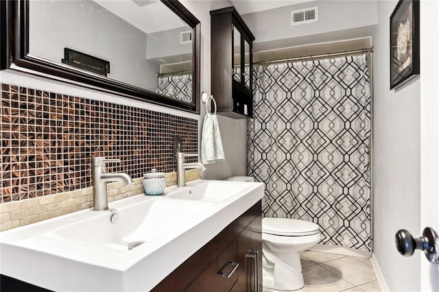 bathroom with tile patterned flooring, tasteful backsplash, vanity, and toilet