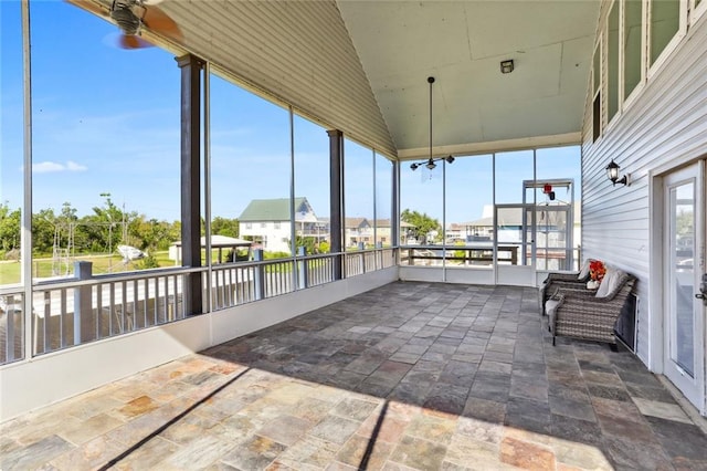 unfurnished sunroom with ceiling fan