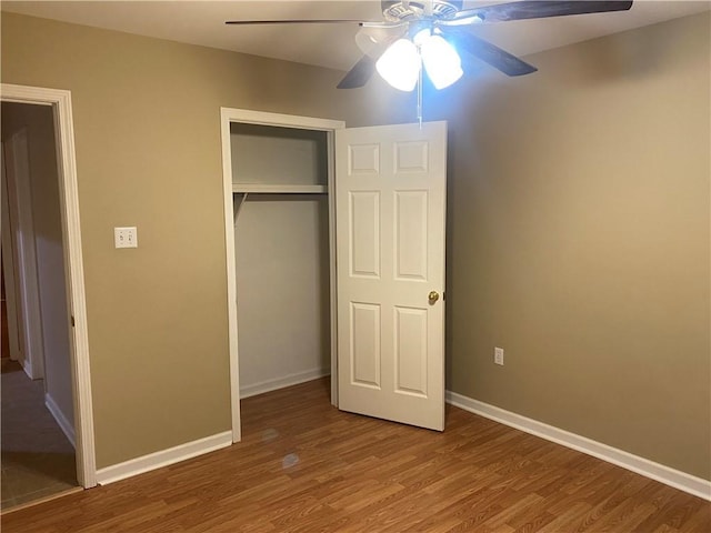 unfurnished bedroom with ceiling fan, a closet, and wood-type flooring