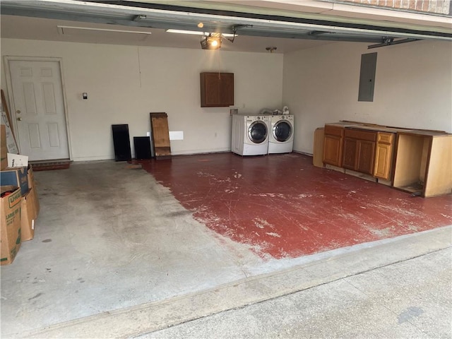 garage featuring electric panel and washing machine and clothes dryer