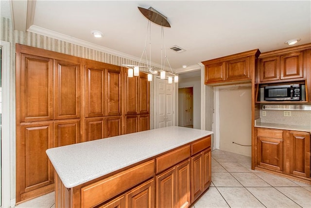 kitchen with crown molding, backsplash, decorative light fixtures, and a center island