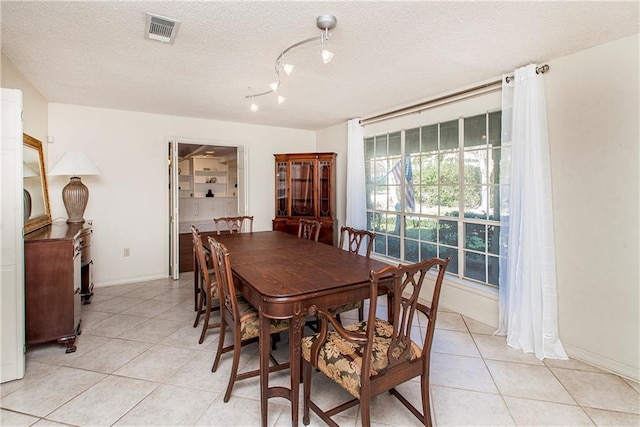 dining area with light tile patterned flooring and a textured ceiling